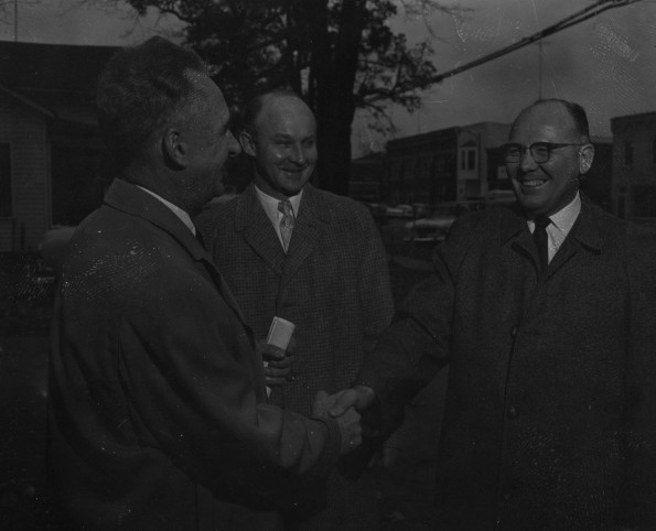 A. W. Bauer speaks with 2 men about Adventist welfare work