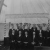 Group of men and women, possibly part of the camp meeting leadership team in the main tent at Michigan camp meeting, possibly in the 1920s