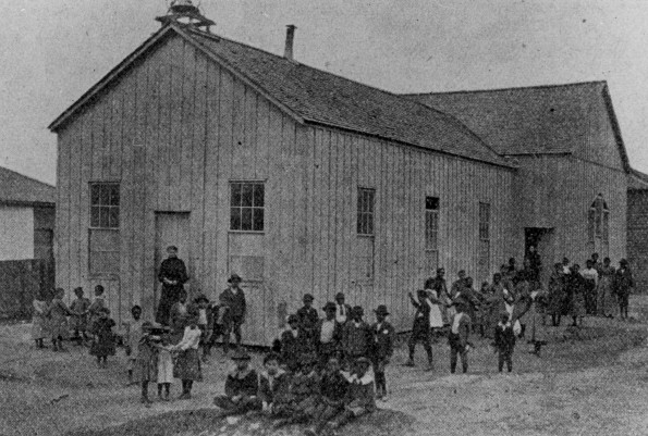 Students and teachers outside the Vicksburg Church School (Miss.) school room and chapel about 1900