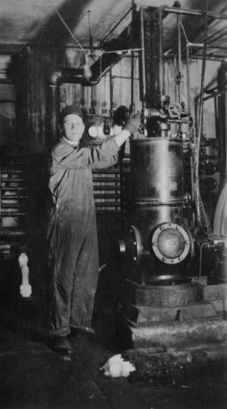 Man tending boiler or some other industrial equipment