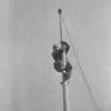 Unknown man climbing a flagpole