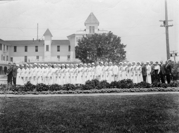 Paradise Valley Sanitarium nurses and other staff, 1919, with part of the building