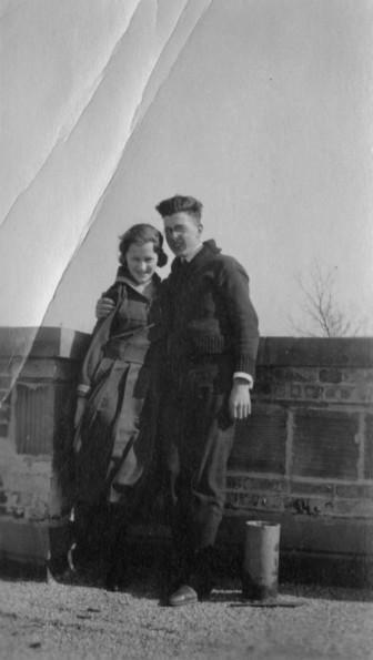 Man and lady pose together on the roof of a building