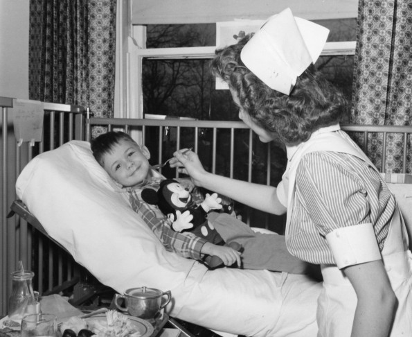 Hinsdale Sanitarium and Hospital student nurse helps a young patient finish his meal