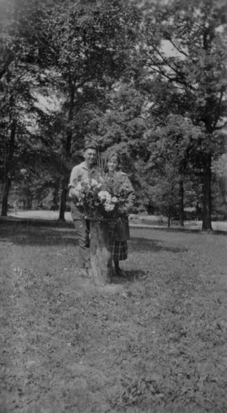 Unknown man and woman posing with some flowers