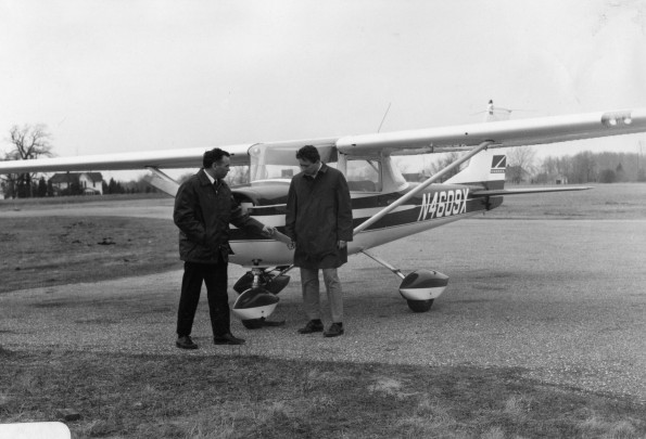 Two men in front of a plane at Andrews University Airport