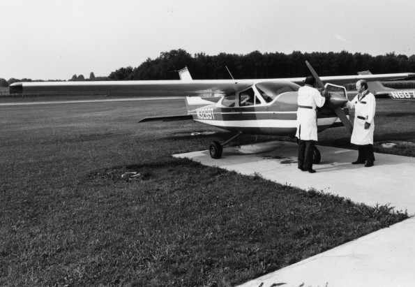 Two men inspecting the propeller of a plane at Andrews University Airport