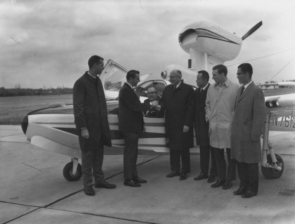 Five men greating a person who arrived at Andrews University Airport by plane