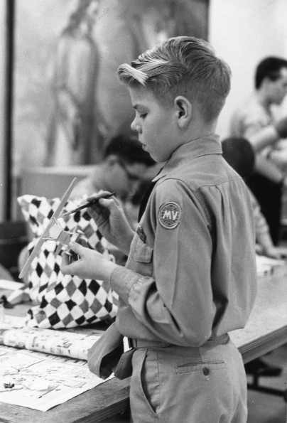 [A young Pathfinder working on a model airplane]