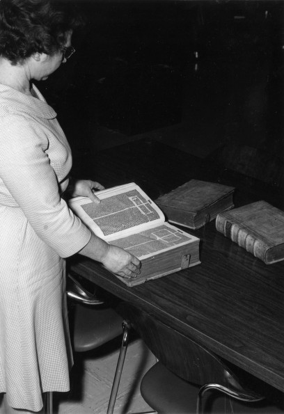 [Mary Jane Mitchell looking at some old Bibles donated to the James White Library]