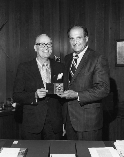 Dr. Cobb receives badge of office as medical director of Los Angeles County Sheriff's department from Sheriff Peter J. Pitchess.