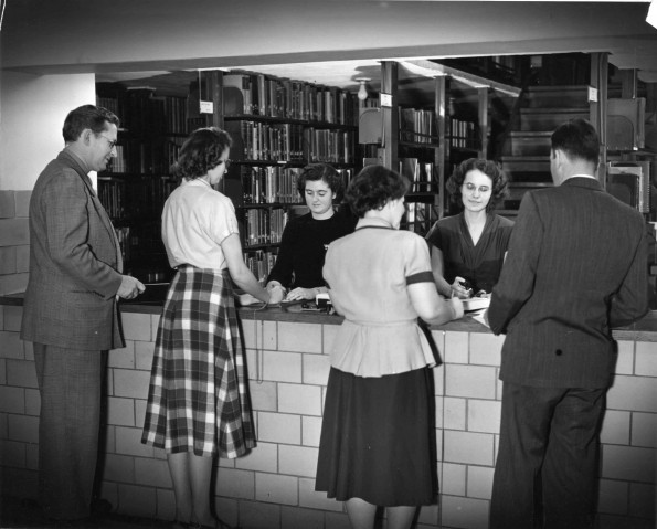 [Students at the circulation desk of Emmanuel Missionry College library]