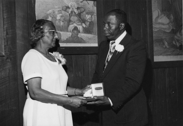[Natelkka Burrell is presented with an award in recognition of nearly 50 years of service]