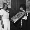 [Natelkka Burrell is presented witha painting at a dinner honoring her years of service to Seventh-day Adventist education]