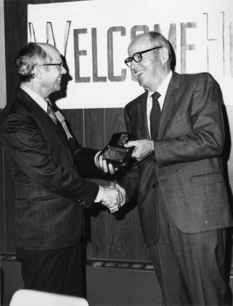[Wesley Christiansen accepting a plaque from Richard Hammill during Andrews University's 1972 alumni homecoming]