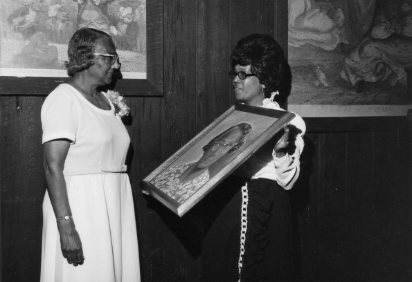 [Natelkka Burrell is presented witha painting at a dinner honoring her years of service to Seventh-day Adventist education]