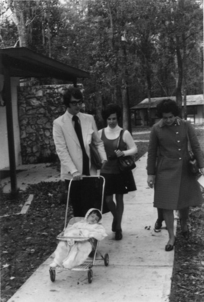 [Gene and Marie Jennings, members of the Christian band,  Ponder, Harp, & Collins,  and who played at the 1972 Andrews University alumni retreat in Florida, are seen walking with their child asleep in the stroller.]