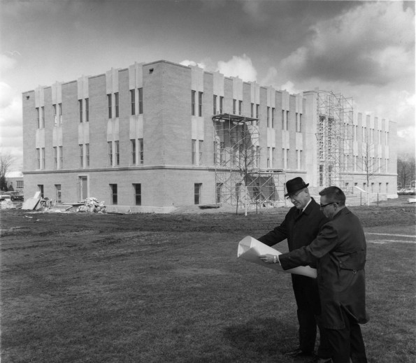 V. E. Garber and John Kriley study blueprints at the construction site of new Andrews University Administration building