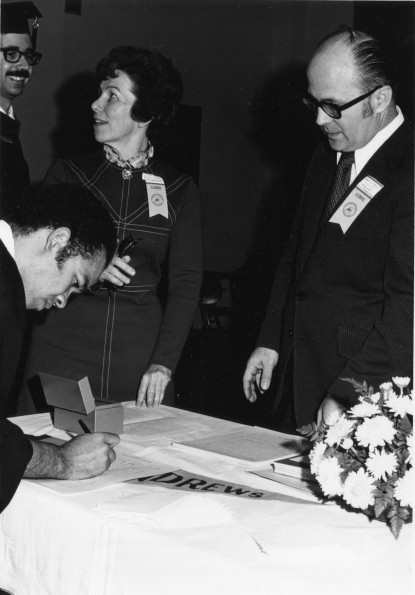 [Elsie Landon Buck and Martin Fishell at registration table for the Andrews University homecoming weekend, 1973]