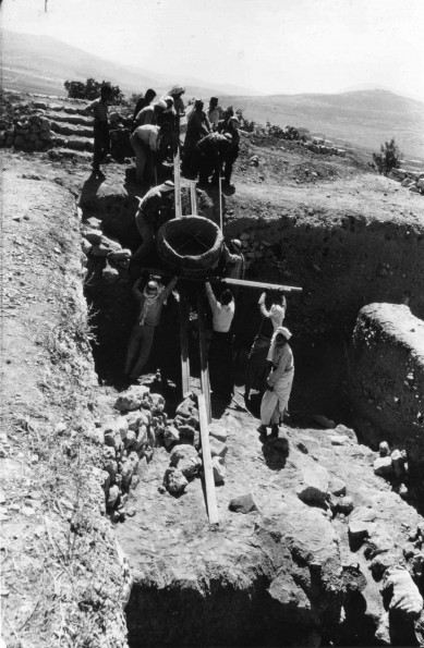 [Siegfried Horn and other archaeologists pulling a stone vat out of one of the squares at the archaeological site of Shechem]